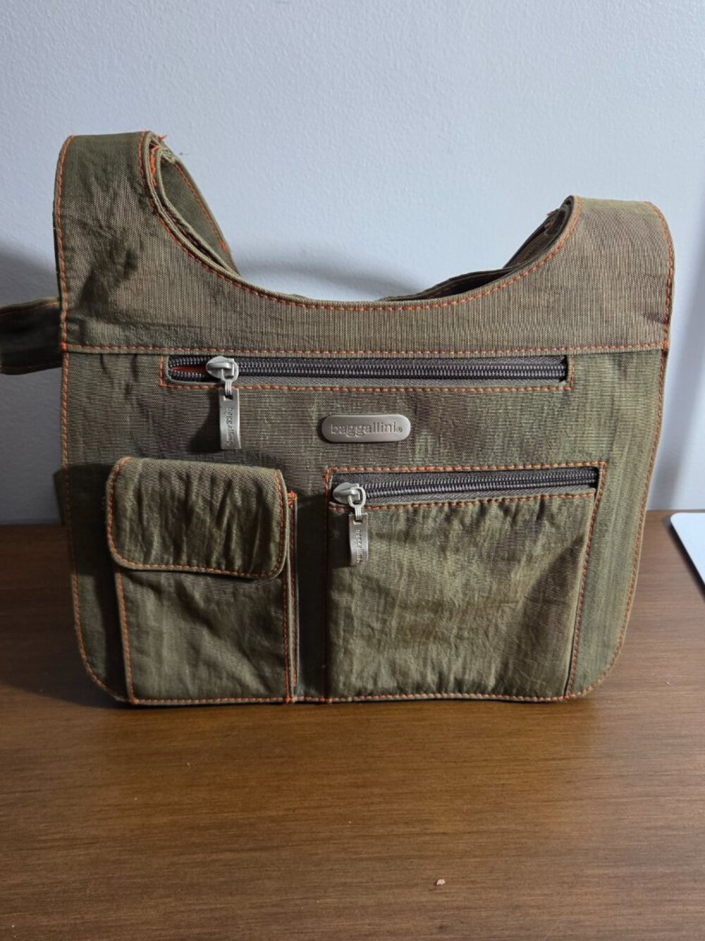 BAGGALLINI MULTI POCKET OLIVE GREEN CROSSBODY TRAVEL BAG FEATURING ORANGE CONTRA
